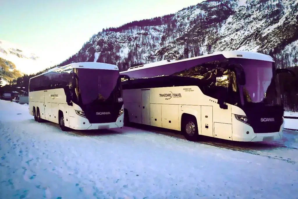 High-capacity Tranzcare large coach showing its expansive wheelbase, engineered for long-distance group travel. A long-distance Tranzcare large executive coach engineered with a low-emission Euro 6 engine for international cross-border group transit.