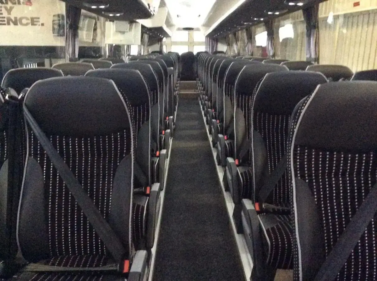 Wide-angle interior shot of a Tranzcare 49 to 57-seat large coach cabin emphasising generous legroom and passenger spacing.