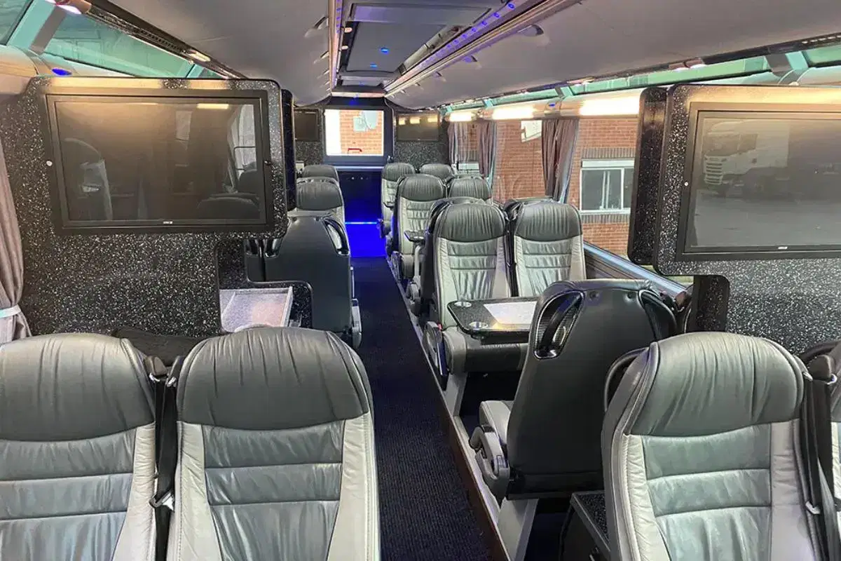 Interior cabin of a luxury Tranzcare executive coach featuring modern leather seating and ambient LED mood lighting.
