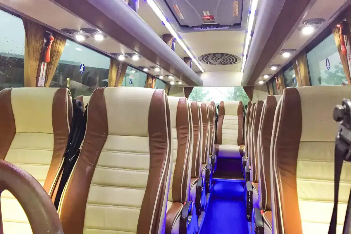 Luxury Mid Sized Coach hire in Manchester. Medium sized luxury coach interior with cream and brown leather seats and blue low level lighting