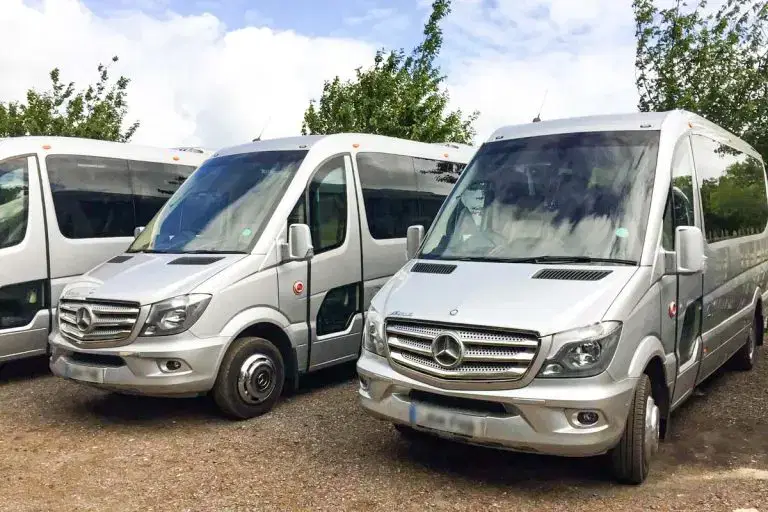 Front view of a sleek Tranzcare luxury 30-seater midi coach demonstrating premium corporate transport presentation.