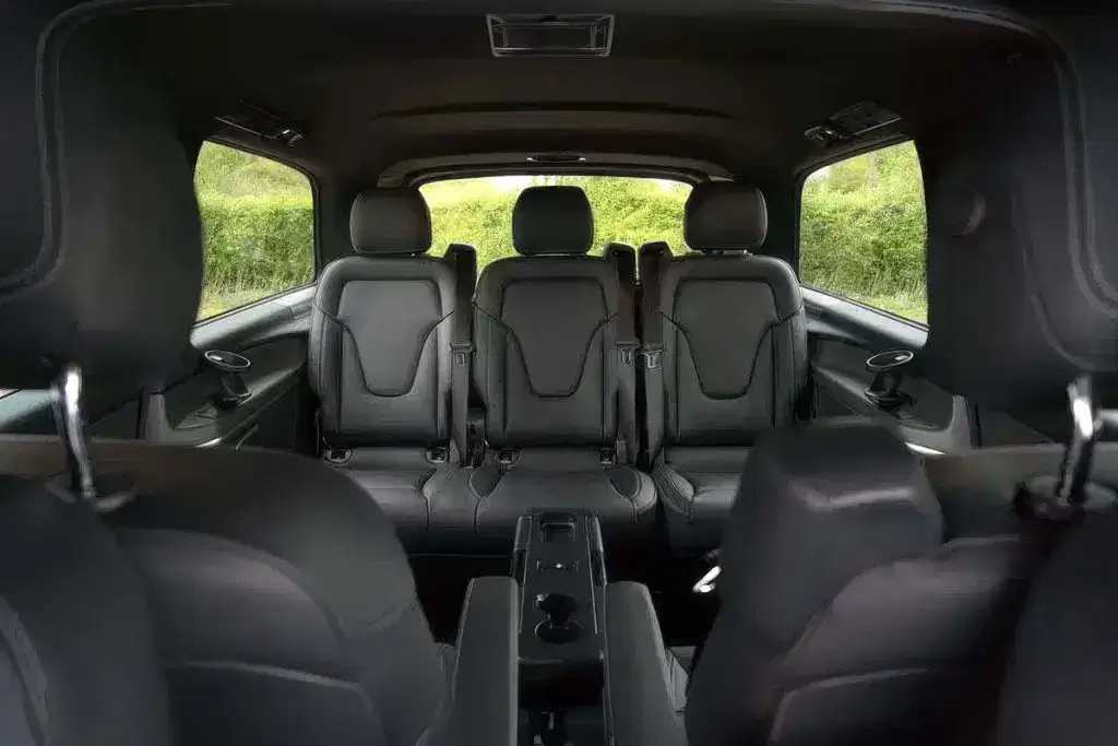 Luxury leather seating and conference table setup inside a Tranzcare chauffeured Mercedes MPV, tailored for executive business travel in Manchester.
